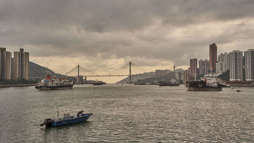 Sailboats in sea against cloudy sky