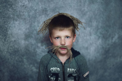 Portrait of boy wearing strings against wall