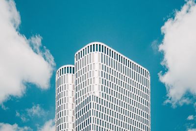 Low angle view of skyscraper against blue sky