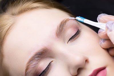 Close-up of young woman holding thermometer
