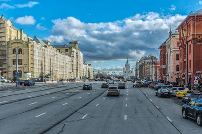 Cars on road in city against sky