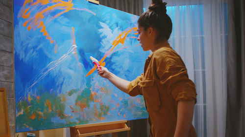 Young woman painting at home