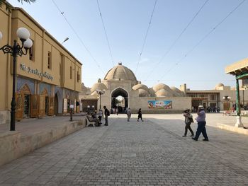 People walking on street amidst buildings in city