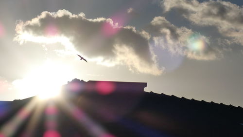 Low angle view of silhouette bird flying against sky