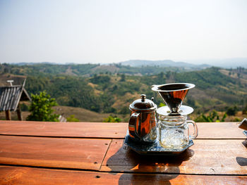 Tea cup on table against sky