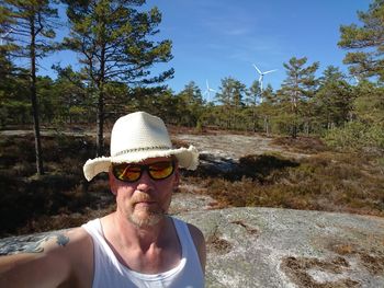 Portrait of mature man wearing sunglasses against trees