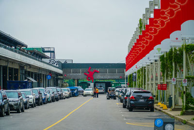 Cars on road in city against sky