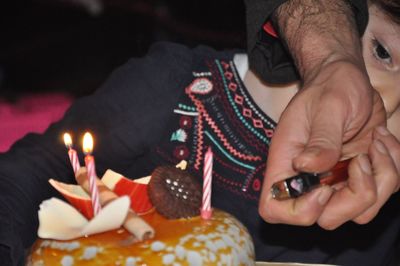 Low angle view of hands holding candles