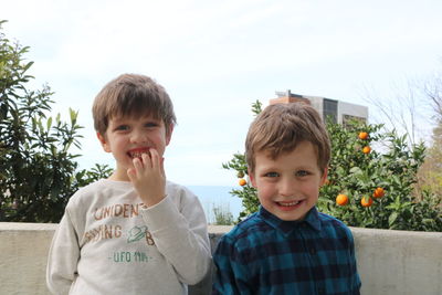 Portrait of happy boy smiling against sky