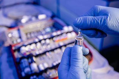 Close-up of paramedic hands holding ampoule medication in ambulance of emergency medical service.