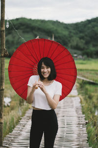 Portrait of a smiling woman standing in rain