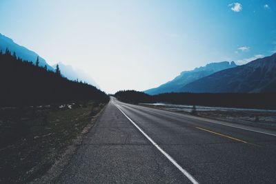 Road by mountains against clear sky