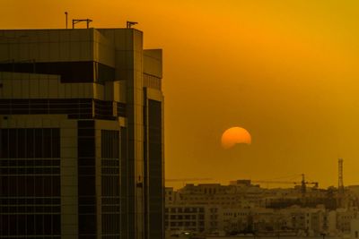 Silhouette buildings against sky during sunset