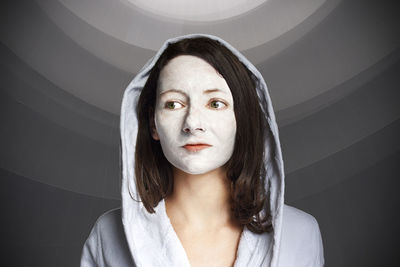 Close-up of woman with facial mask against wall