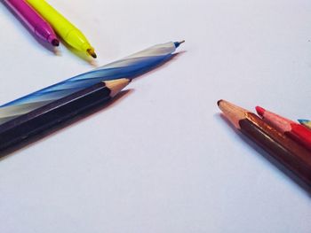 High angle view of colored pencils on white background