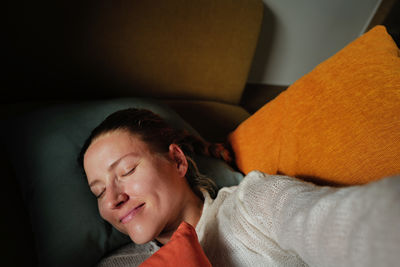 Woman relaxing on the colorful pillows smiling