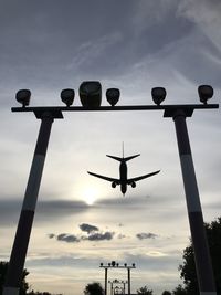 Low angle view of silhouette airplane against sky during sunset