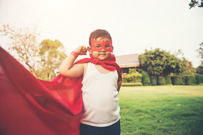 Boy with cape and eye patch playing in park
