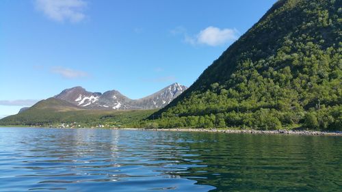 Scenic view of lake by mountains against sky