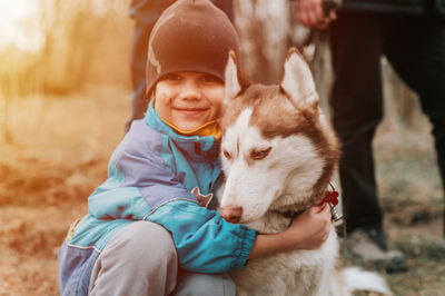 Kid and his friend husky siberian dog. portrait little child boy hugging cute white brown animal pet