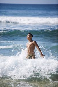 Full length of shirtless man in sea