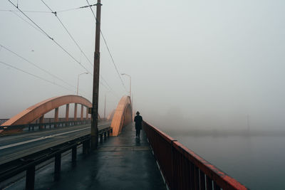 Silhouette bridge against sky during rainy season