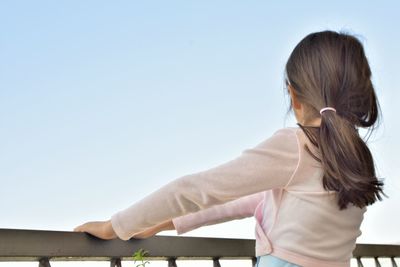 Rear view of a child against clear sky