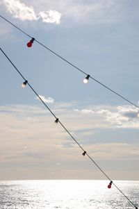 Low angle view of fishing net on sea against sky