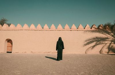 Rear view of woman with umbrella standing on land