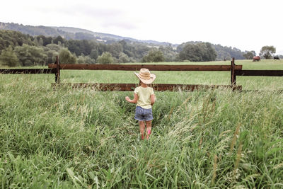 Full length rear view of man standing on field
