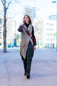 Beautiful woman using mobile while walking on the street