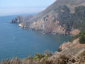 Scenic view of sea and mountains against sky