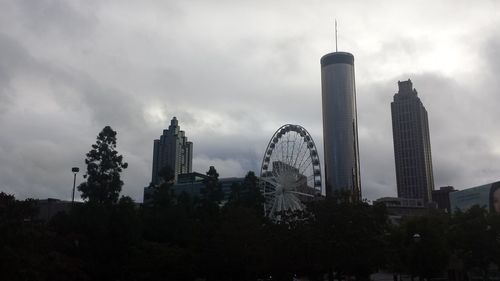 Buildings in city against cloudy sky