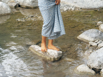 Low section of woman standing in lake