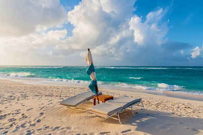 Sunbeds beach against sky