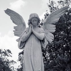 Low angle view of angel statue against sky