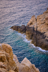 High angle view of rocks on sea shore