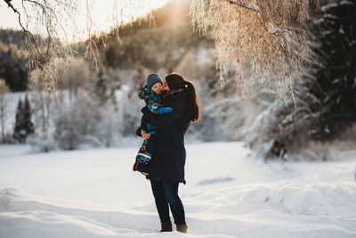 Full length of woman photographing during winter