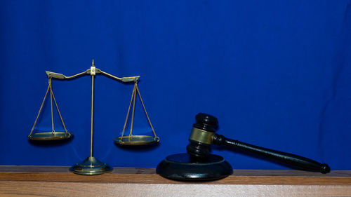 Metallic structure on table against blue background