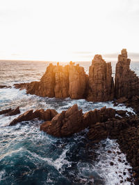 Rocks on beach against clear sky