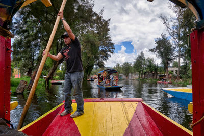 People standing on boat in lake