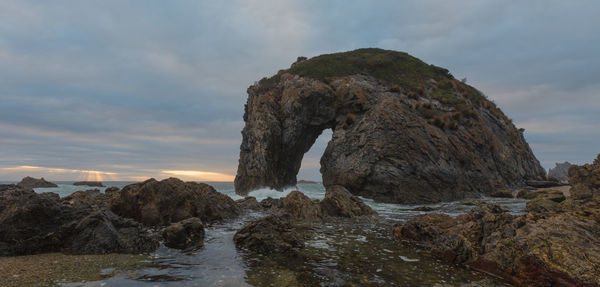 Rock formations by sea against sky