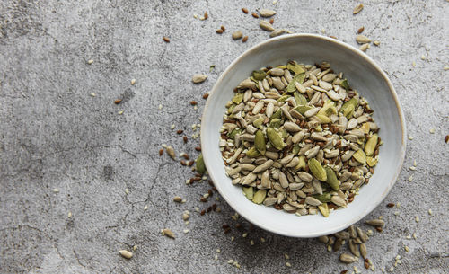 Mix different seeds for a healthy salad, bowl on a gray concrete background