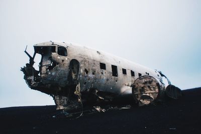 Abandoned airplane on airport runway against sky