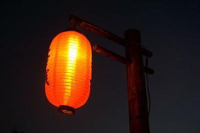 Low angle view of illuminated lantern against sky at night