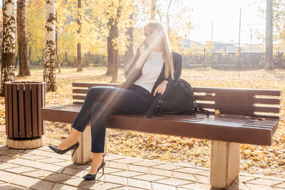 Full length of woman sitting on seat