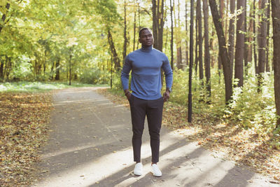 Full length portrait of man standing on footpath