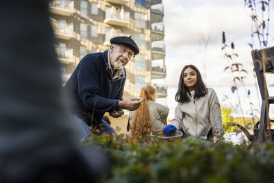 Group of neighbors gardening together in courtyard