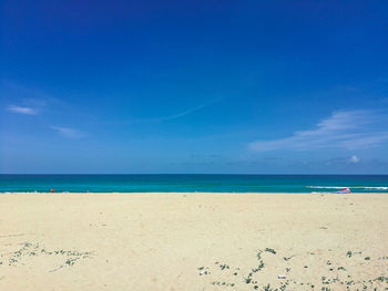 Scenic view of beach against blue sky