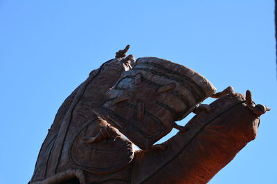 Low angle view of statue against clear blue sky